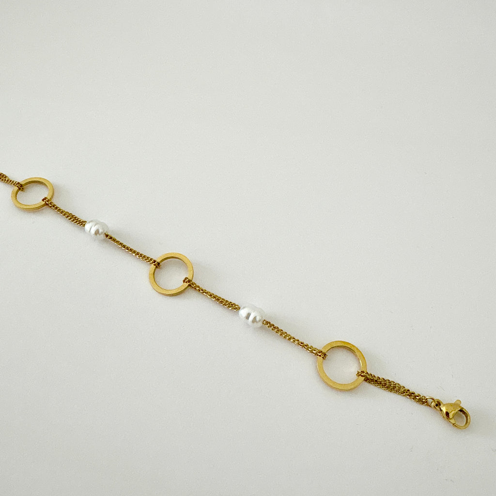 Bracelet Nora - bracelet double chaîne dorée avec anneaux ronds et perles blanches en acier inoxydable